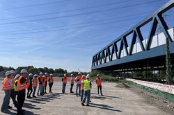 Studierende vor einer Stahlfachwerkbrücke